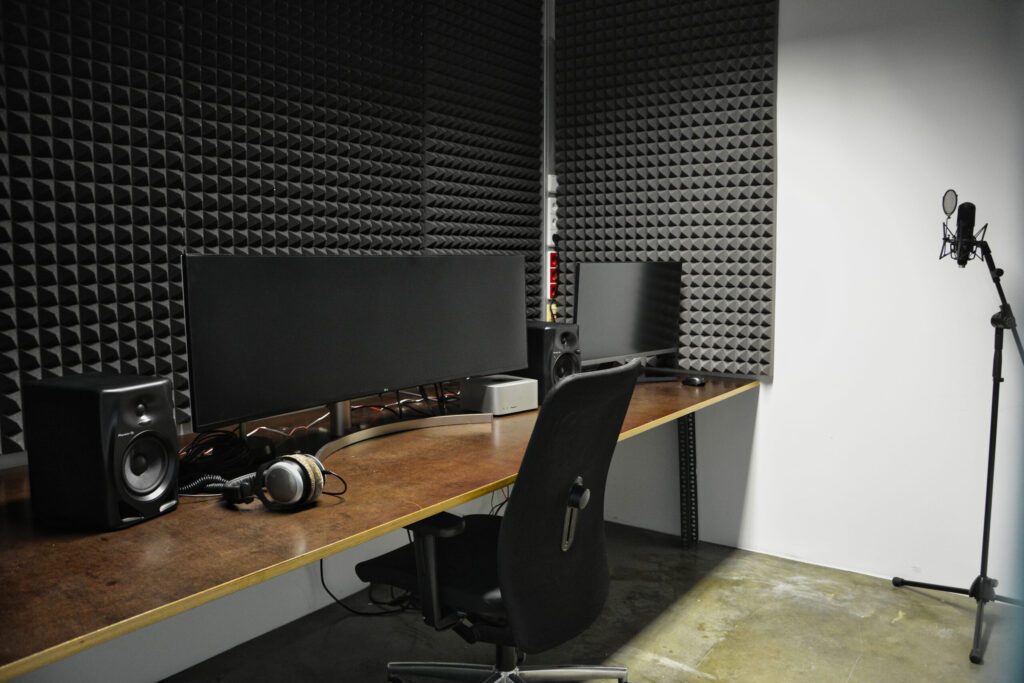 Tonstudio mit Monitoren und Mikrofon, schallisoliert